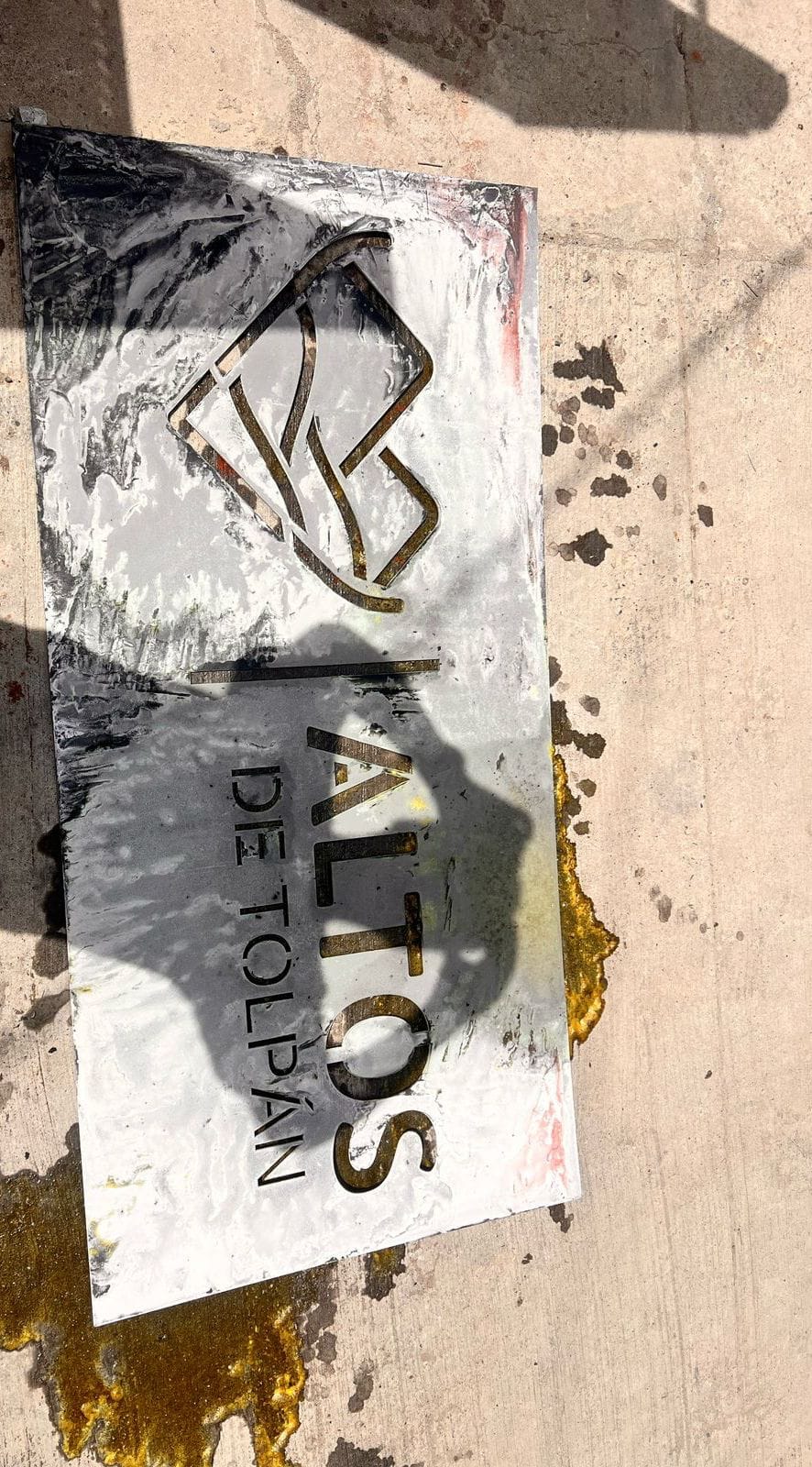 Placa metálica recién cortada con el logotipo de Altos de Tolpán