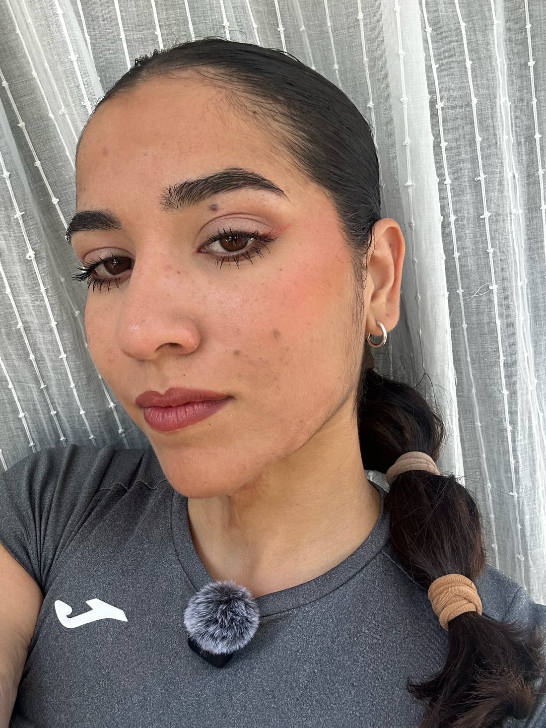 Primer plano de una mujer con sombras difuminadas, cejas definidas y labios en tono rosa